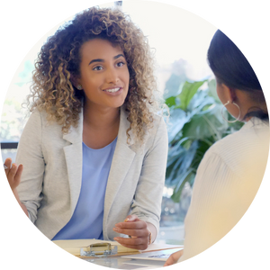 2 women visiting while seated at desk